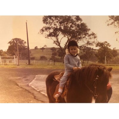 Childhood photo of Rachael Carpani while riding a horse. 